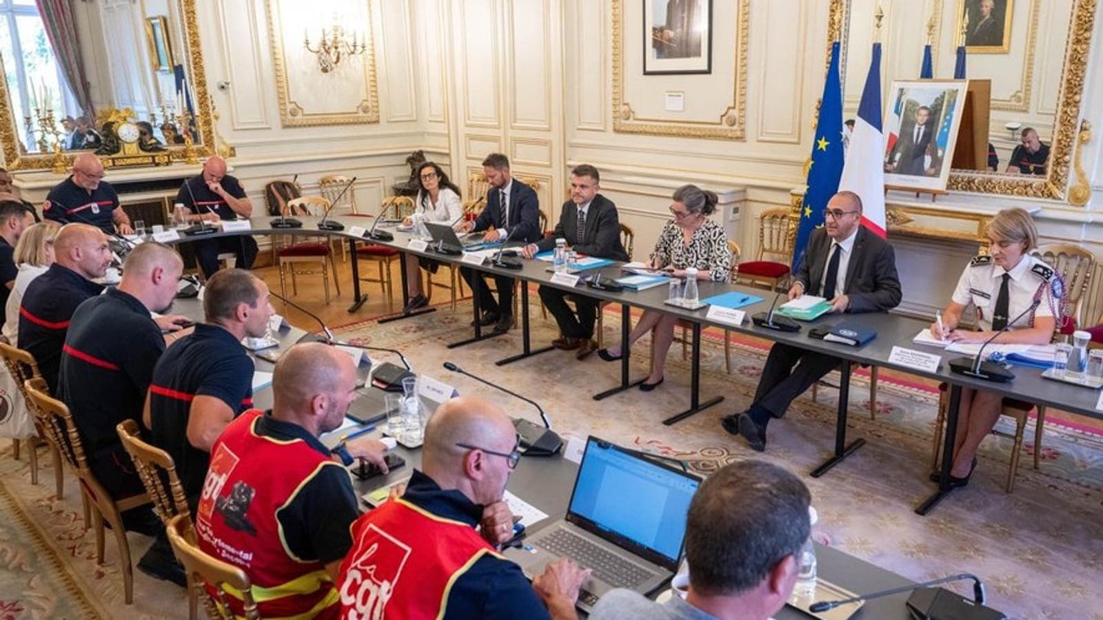 Firefighters' union representatives seated around a table facing government officials at the interior ministry.