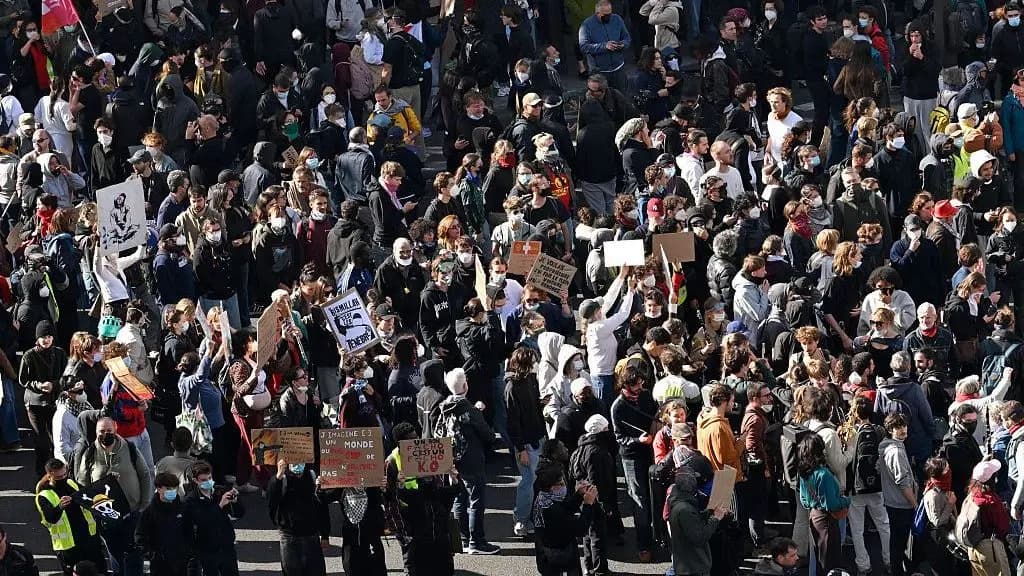 Vue aerienne d'une foule de manifestants portant des masques et des pancartes