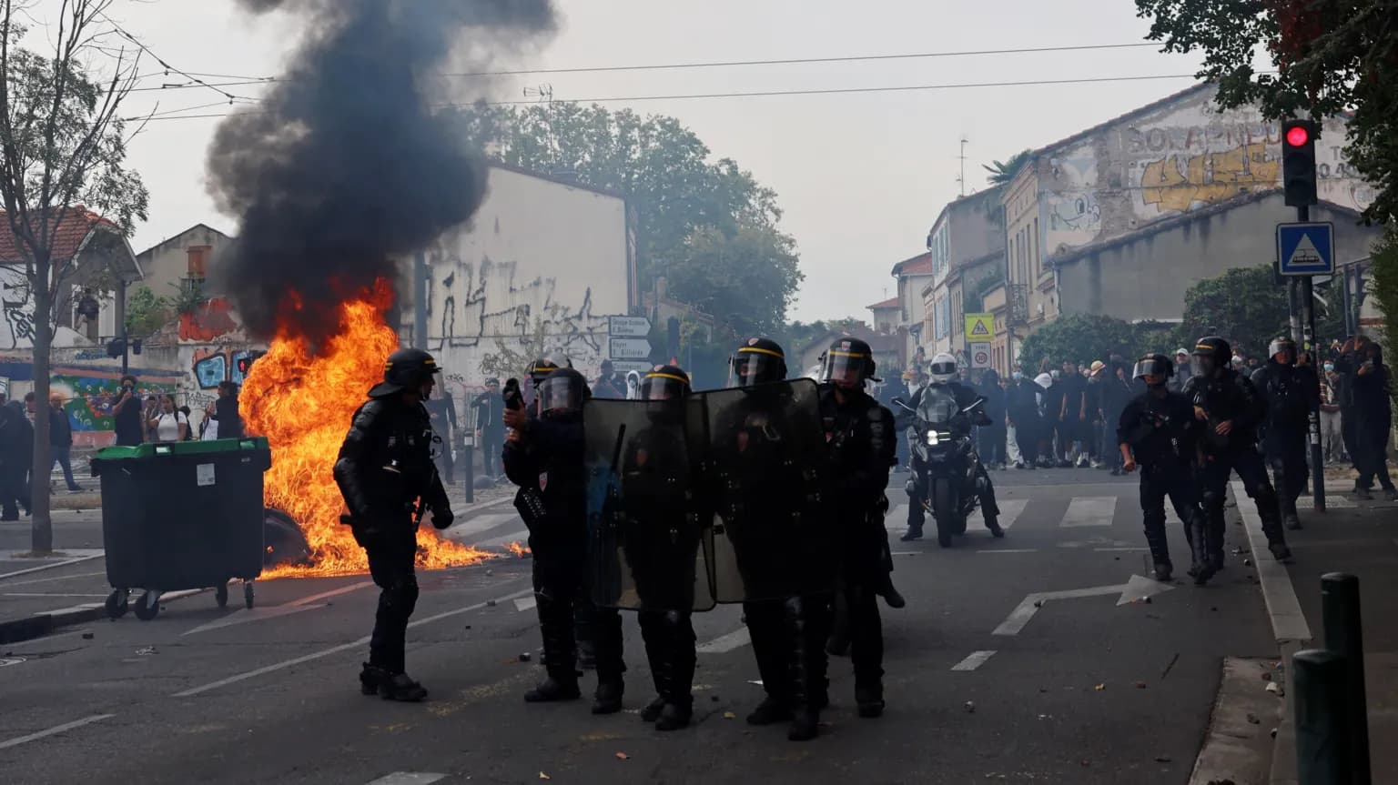Des policiers antiemeutes devant un feu de poubelle lors de manifestations lyceennes