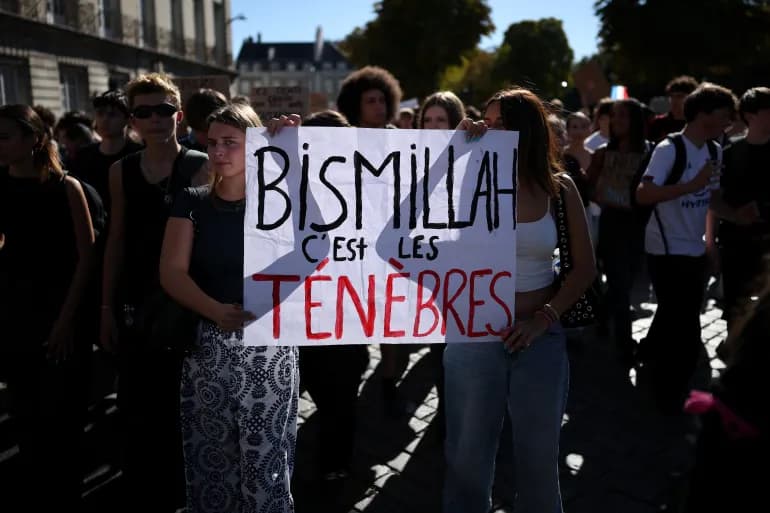 Des manifestantes tiennent une pancarte portant le slogan Bismillah c'est les tenebres