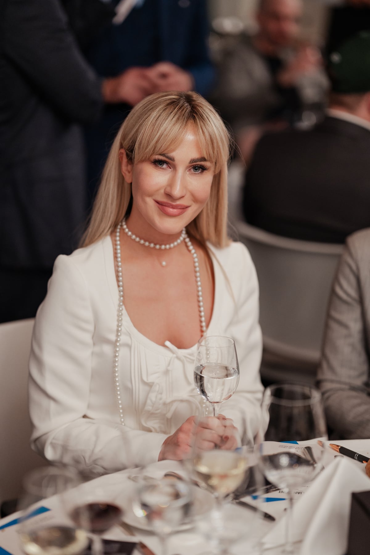 Irina Biss attablée lors d'un dîner de gala.